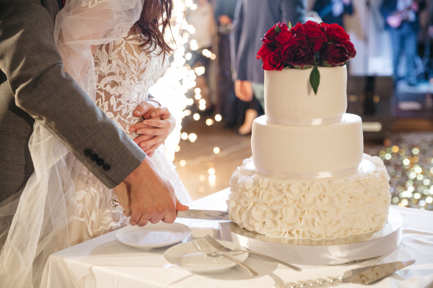 Happy bride and groom cutting wedding cake at Manor on High